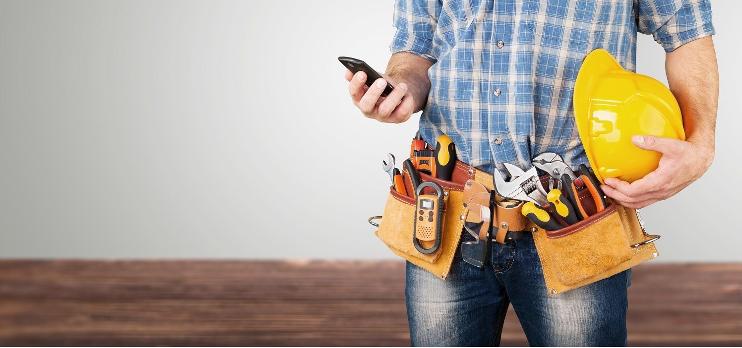 Imagen de hombre con móvil en la mano y herramientas de instalación y mantenimiento